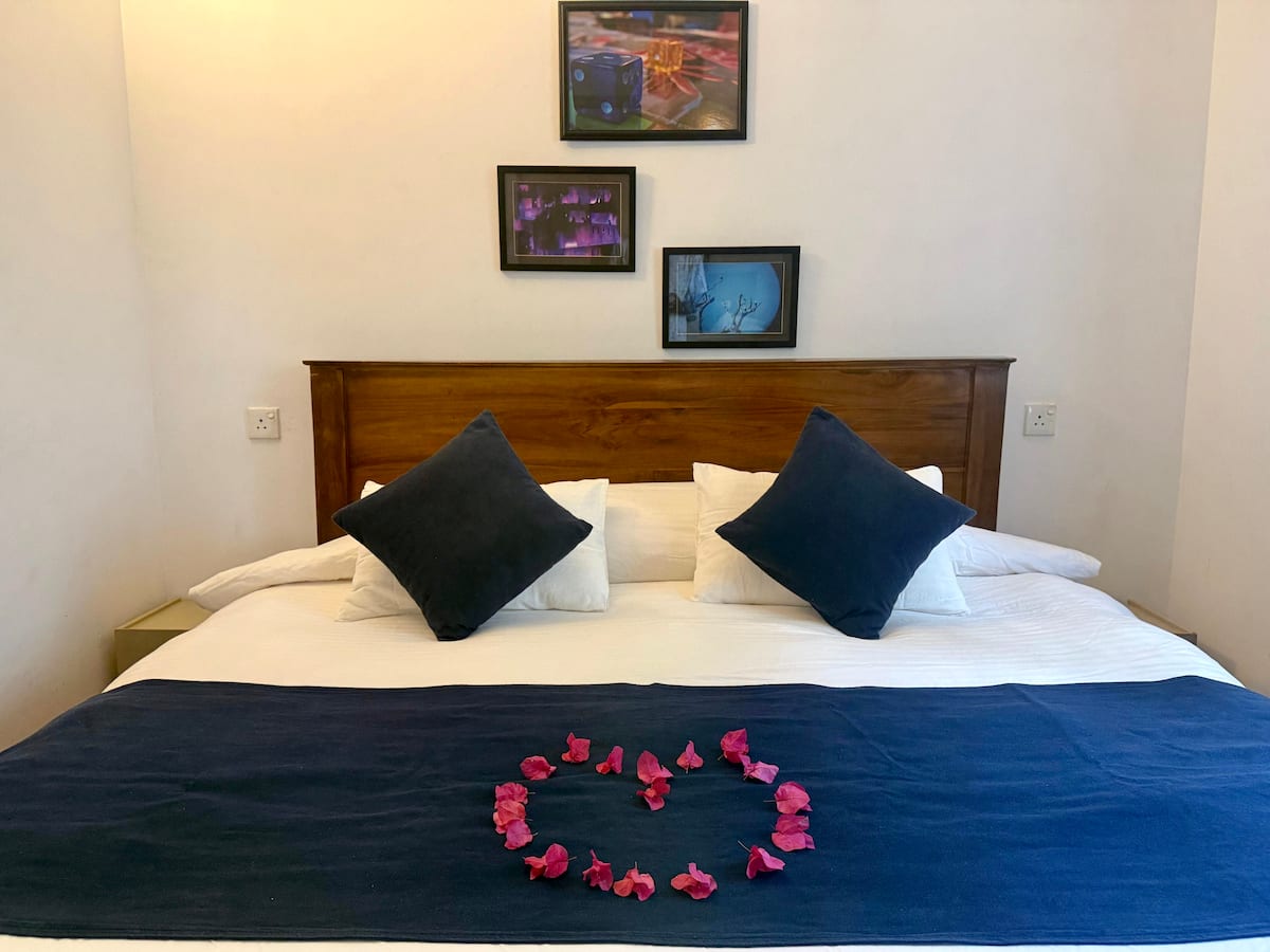 Queen bed with blue accents at Villa Krista, Ella