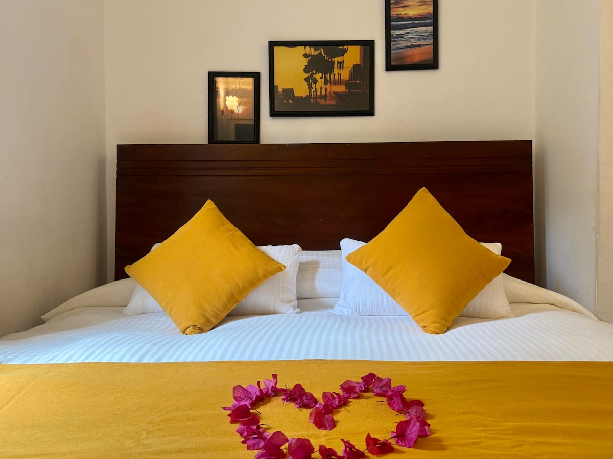 Queen bed with yellow accents at Villa Krista, Ella