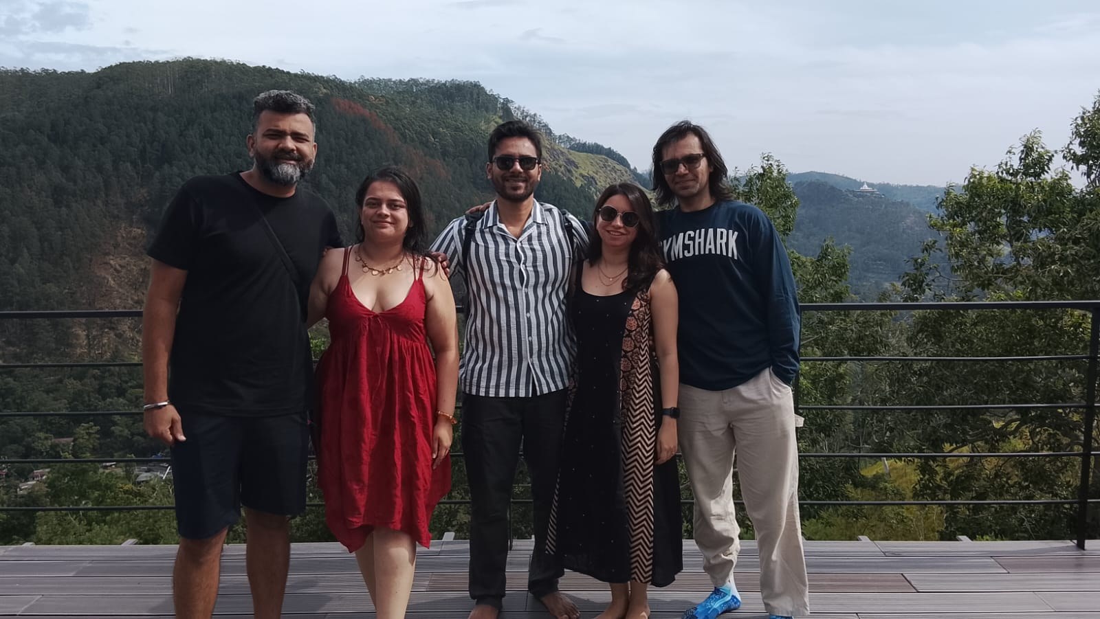 Friends posing together with green hills behind them in Ella, Sri Lanka